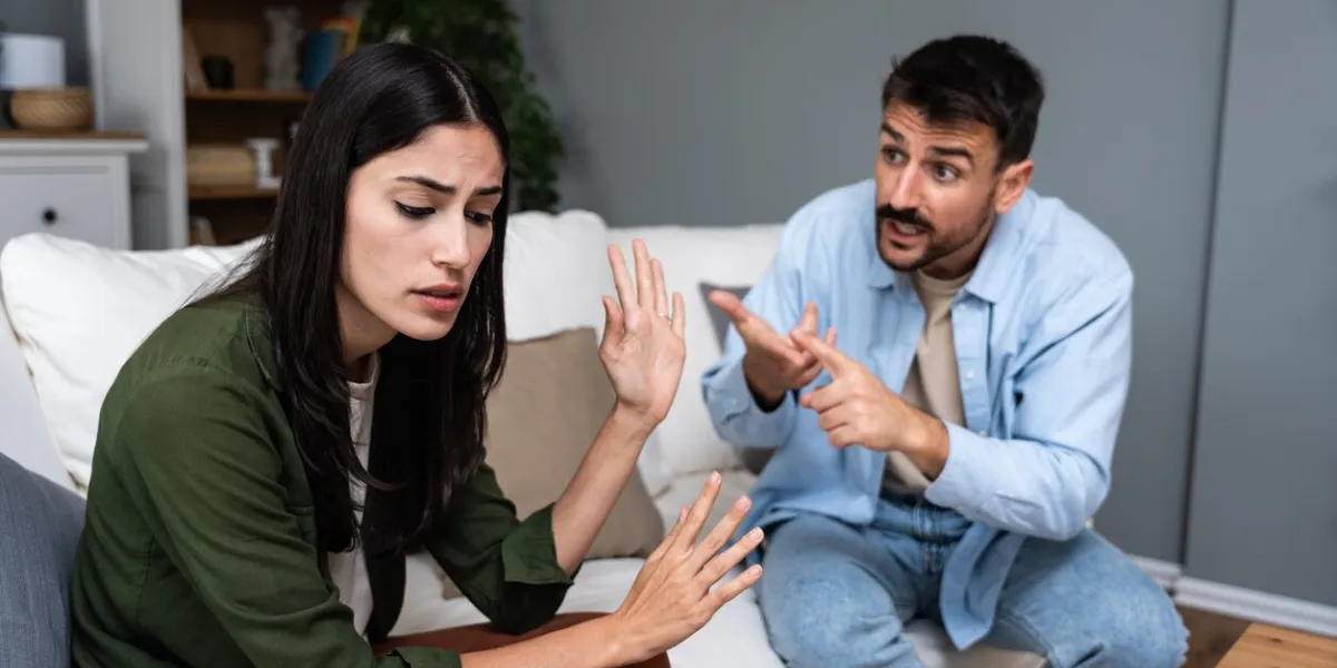 young married couple husband and wife sitting at home having problems in their marriage and a cold relationship a boyfriend and a girlfriend roommates have an argument about spending too much money