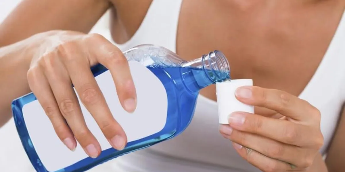 gros plan, de, femme, mains, verser, rince-bouche, dans, bouchon bouteille