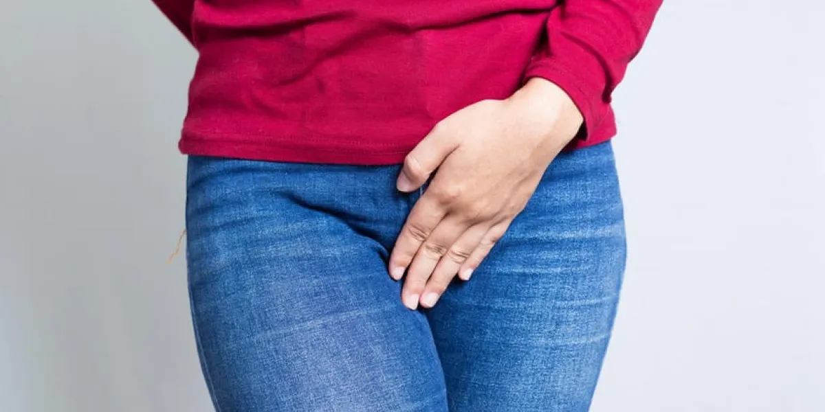 femme avec les mains tenant son entrejambe isolé sur fond blanc