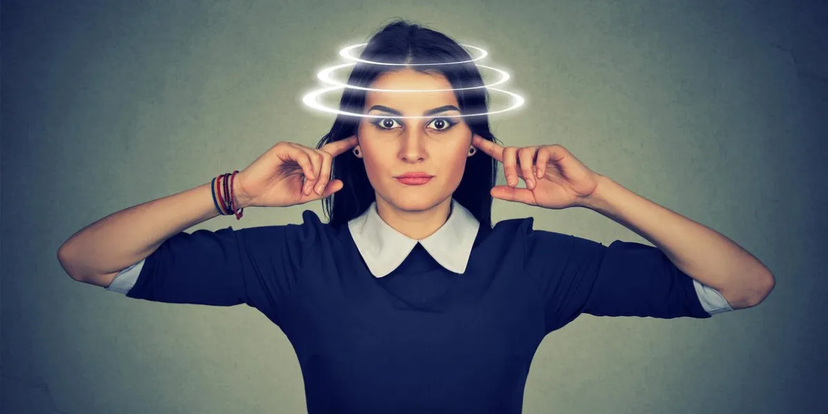 woman with vertigo closing her ears from noise