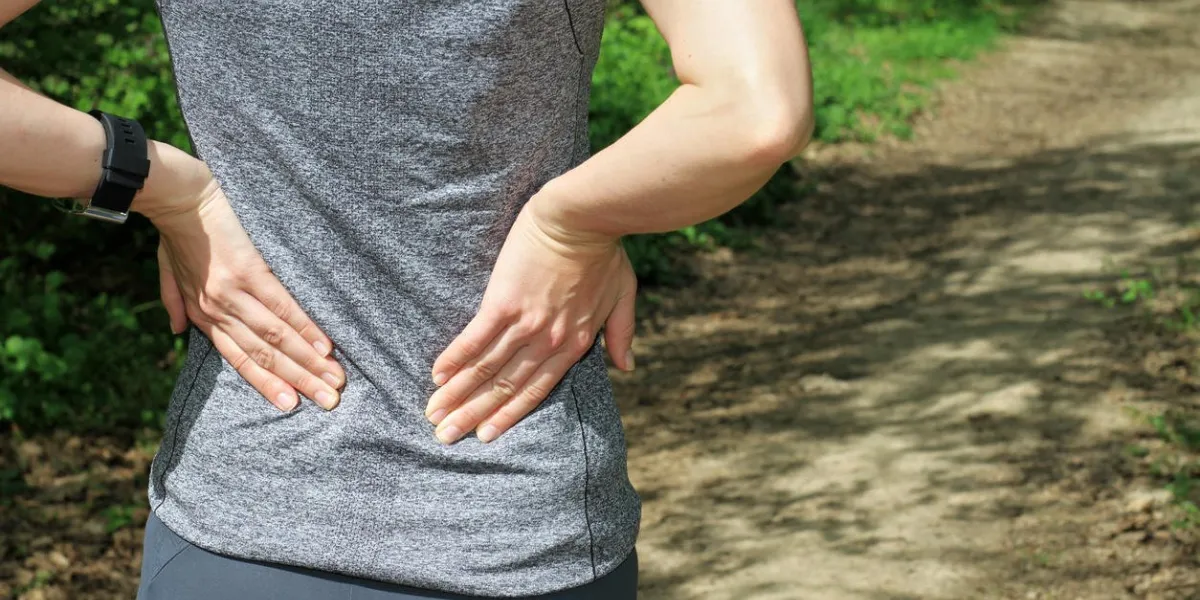 back pain athletic fitness woman rubbing the muscles of her lower back sports exercising injury