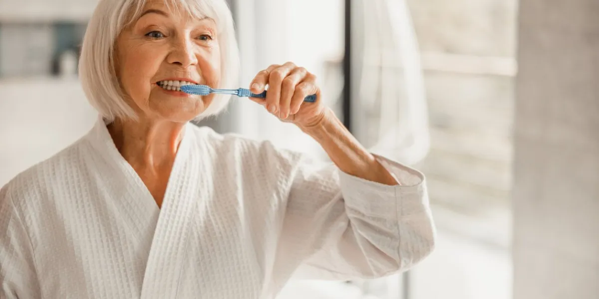 lovely old lady cleaning teeth with toothbrush stock photo