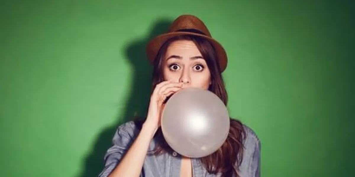 fille séduisante adolescente hipster mignonne soufflant un ballon