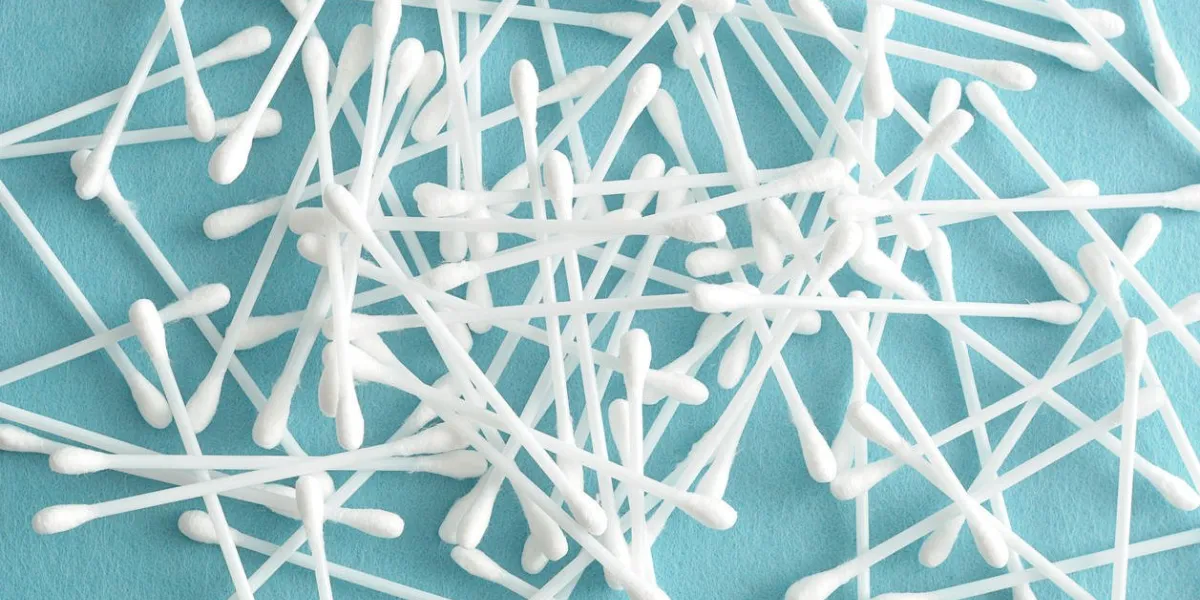 un tas de cotons-tiges isolé sur un fond bleu clair