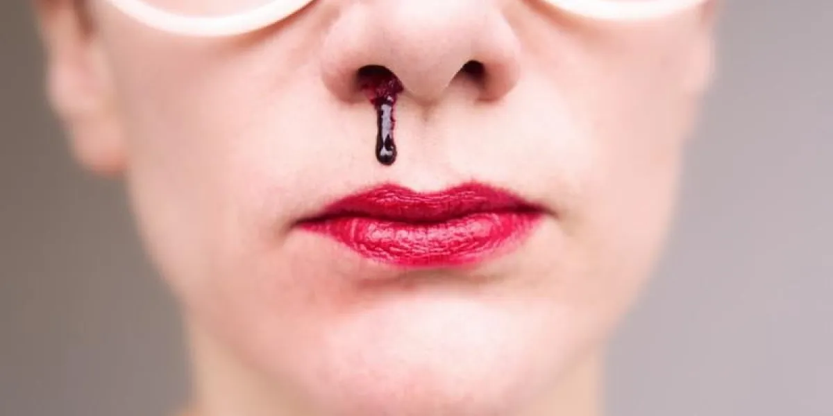 gros plan de femme portant des lunettes et ayant un saignement de nez