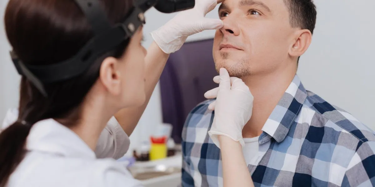 pouvez-vous respirer la personne masculine attentive portant chemise à carreaux regardant vers le haut en appuyant sur ses lèvres
