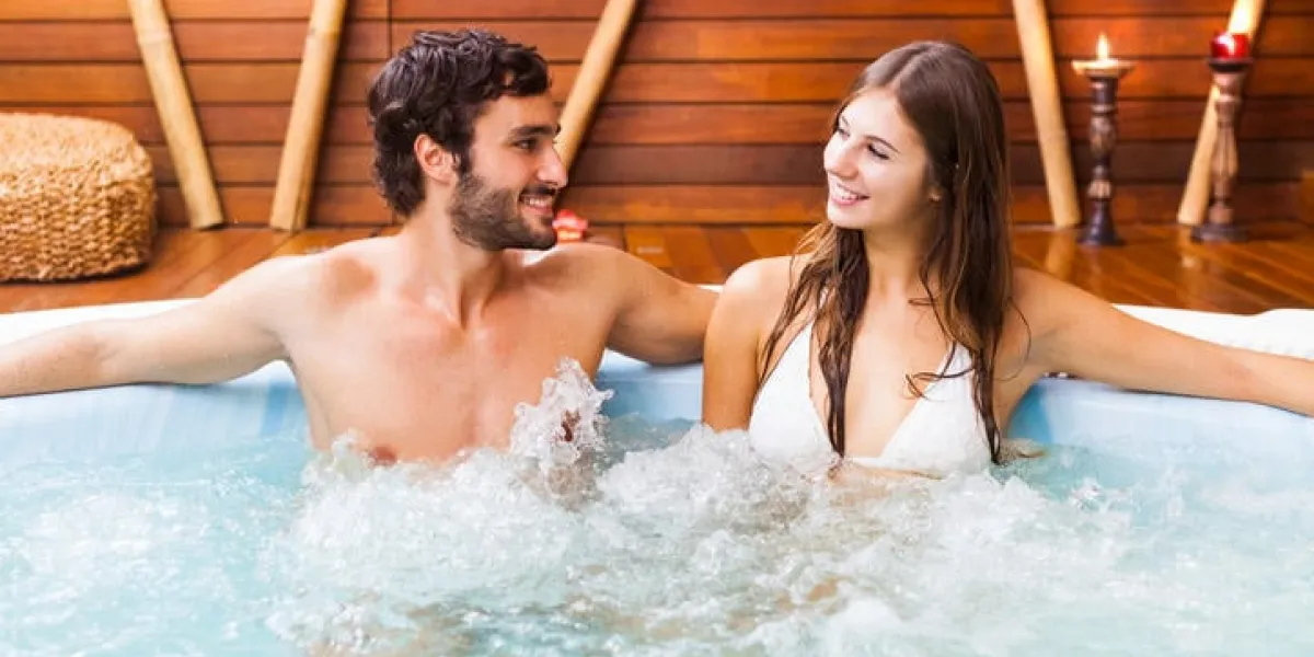couple heureux se détendre dans un bain à remous