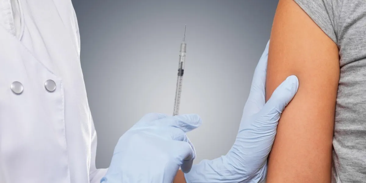 médecin fait la vaccination dans l'épaule du patient