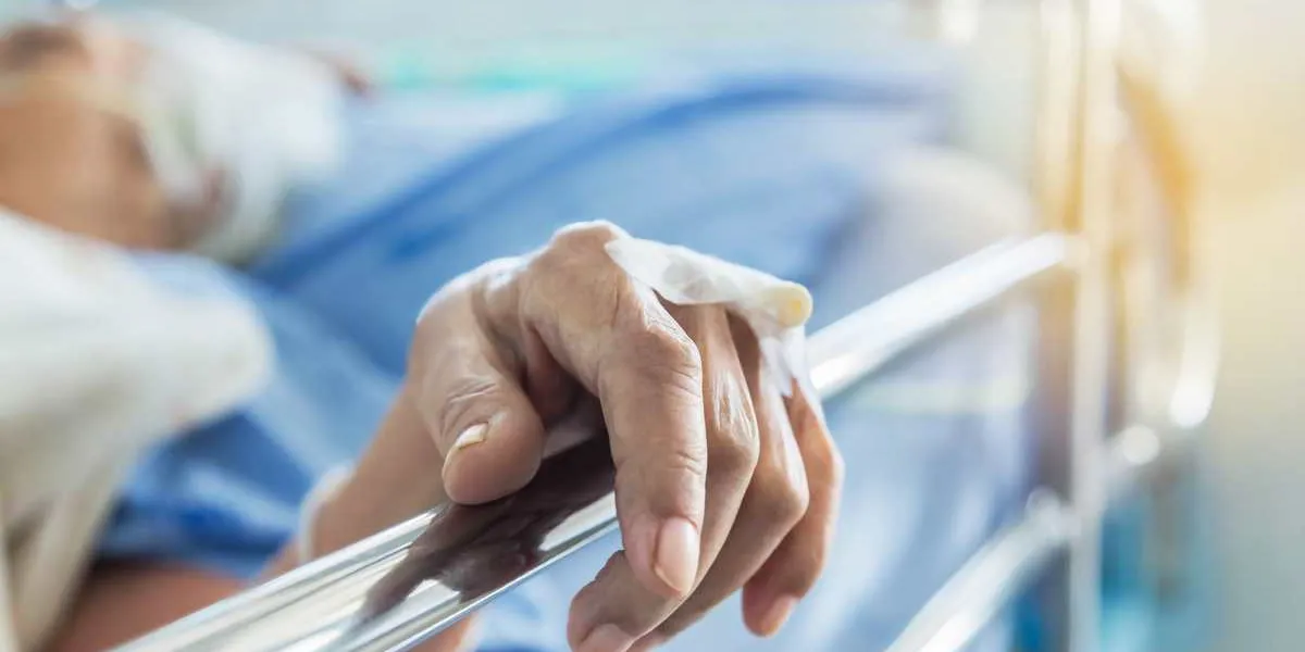 close up hand of elderly patient with intravenous catheter for injection plug in the vein during lying in hospital ward room