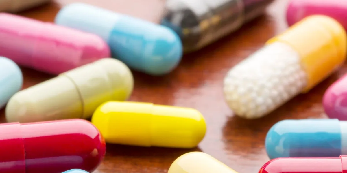 diverses capsules de médecine coloré sur fond de table en bois