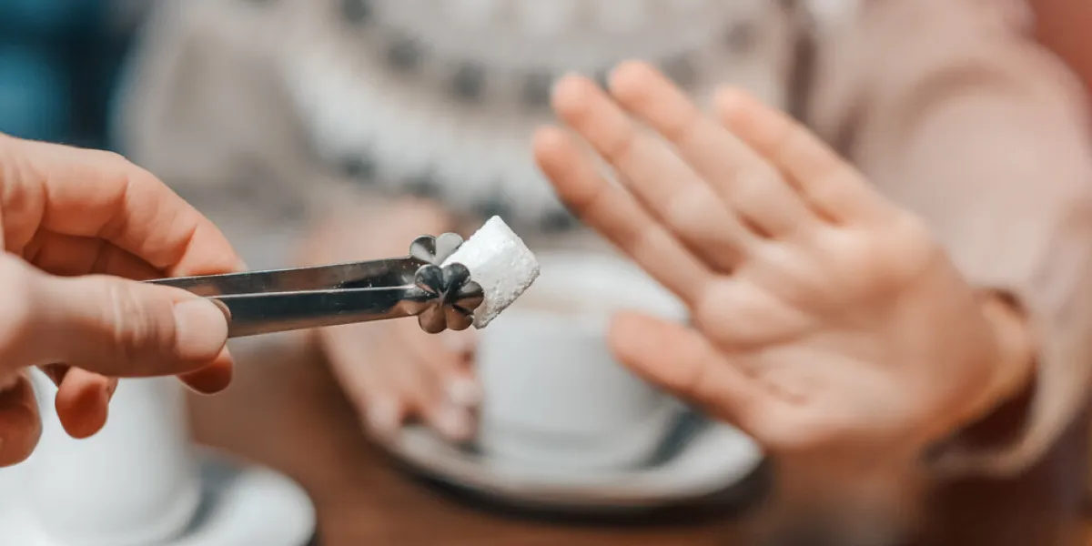 a woman in a cafe refuses a piece of white sugar for her tea say no to sugar and fast carbs diet for diabetes and addiction to sweet junk food