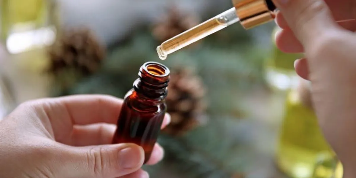 woman filling in bottle with pine essential oil