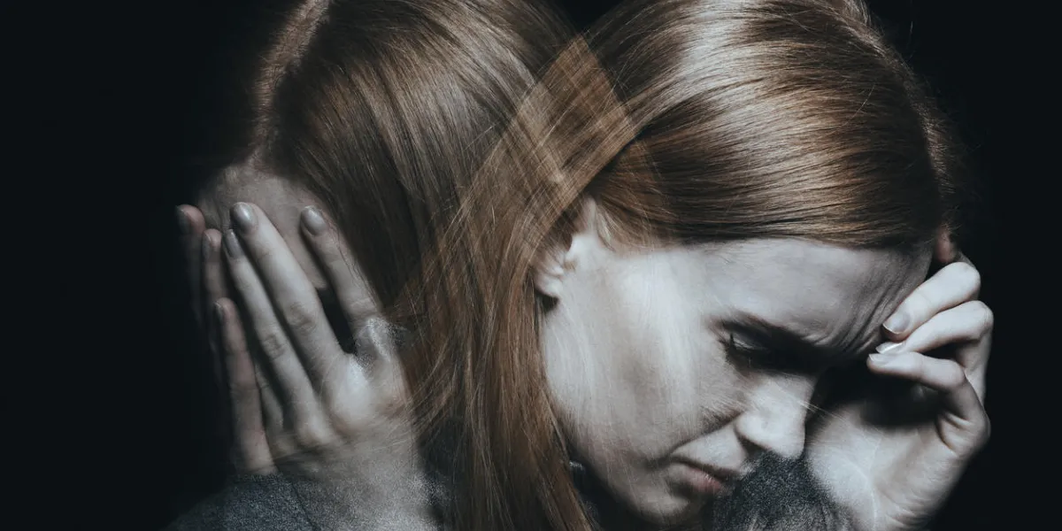 young red haired female with mood disorder crying and having a headache