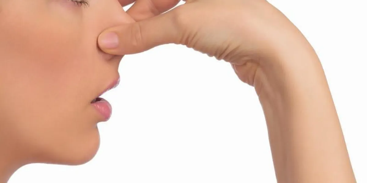 image avec le visage de la femme tenant son nez avec la main