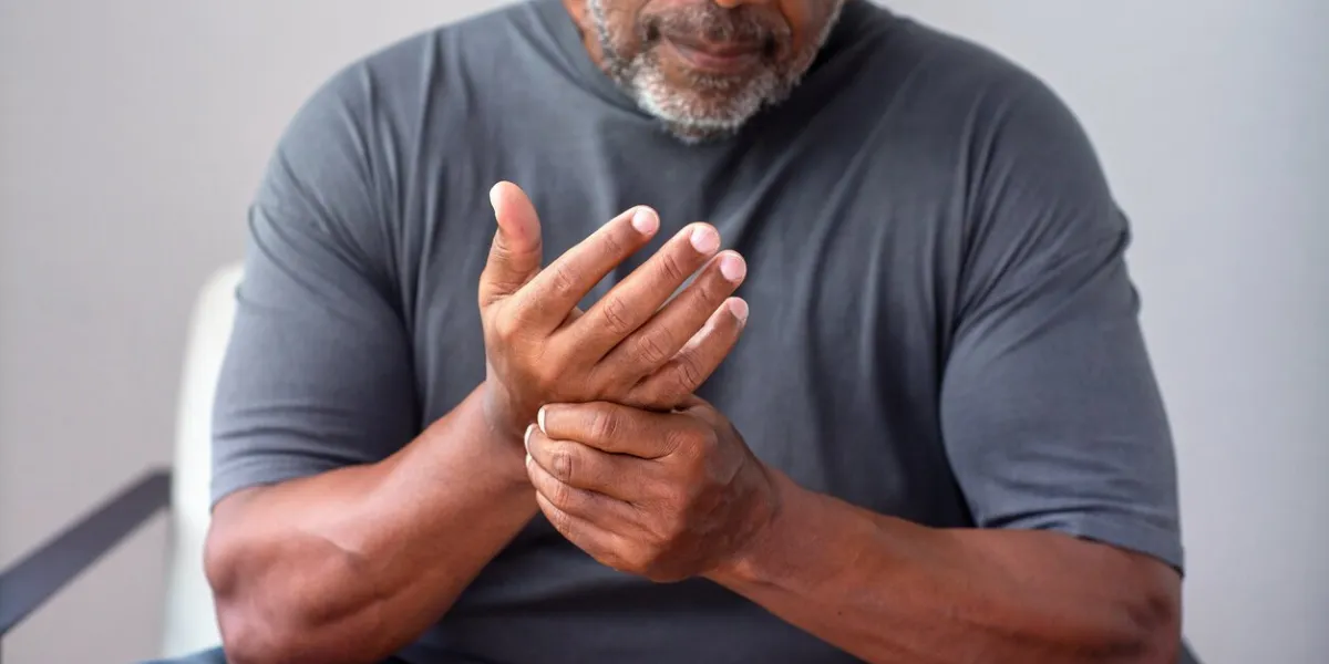 portrait of an older senior man having pain in his hand