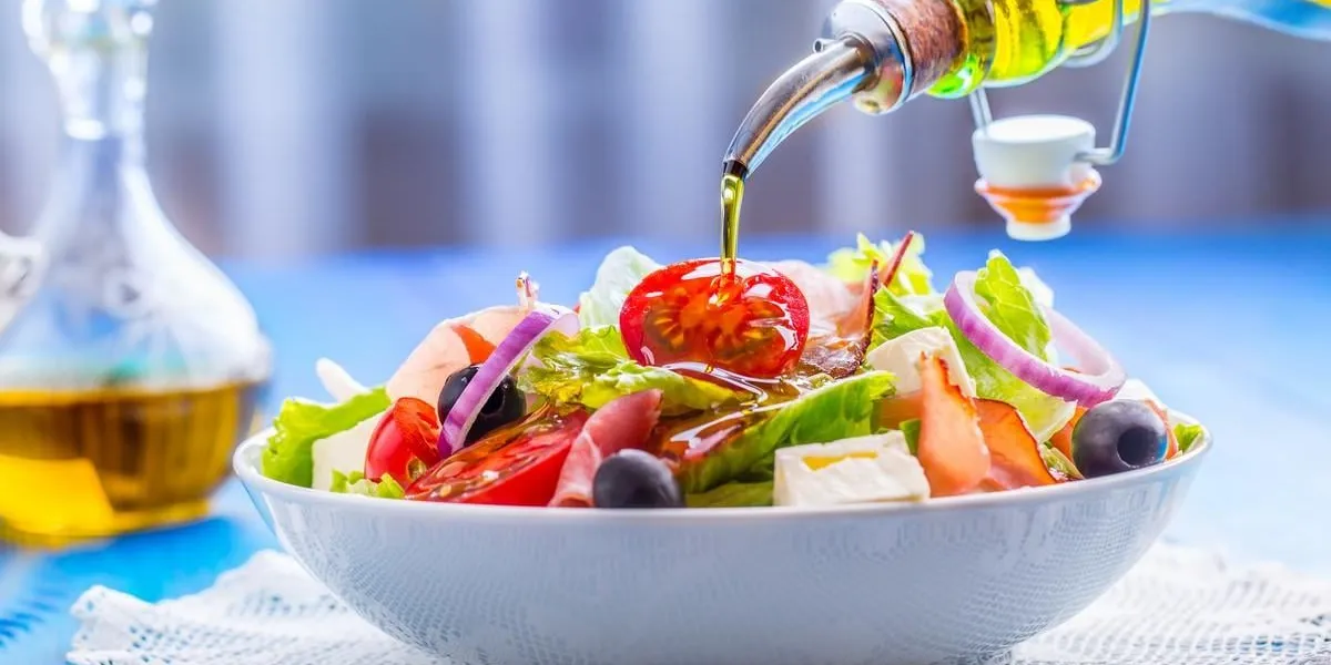 salad fresh summer lettuce saladhealthy mediterranean salad olives tomatoes parmesan cheese and prosciutto pouring olive oil