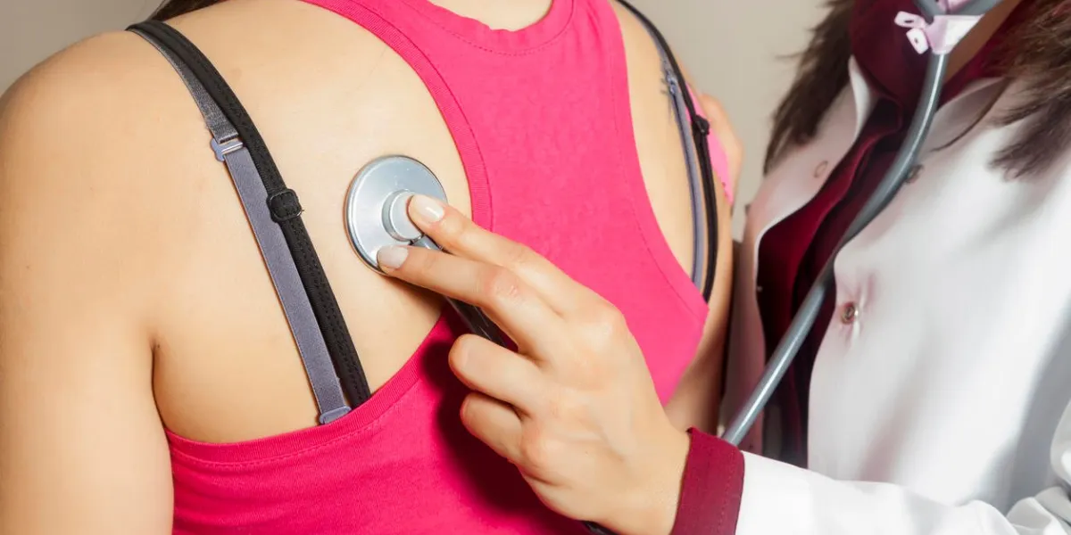 doctor or nurse auscultating patient spine with stethoscope physical therapy closeup composition