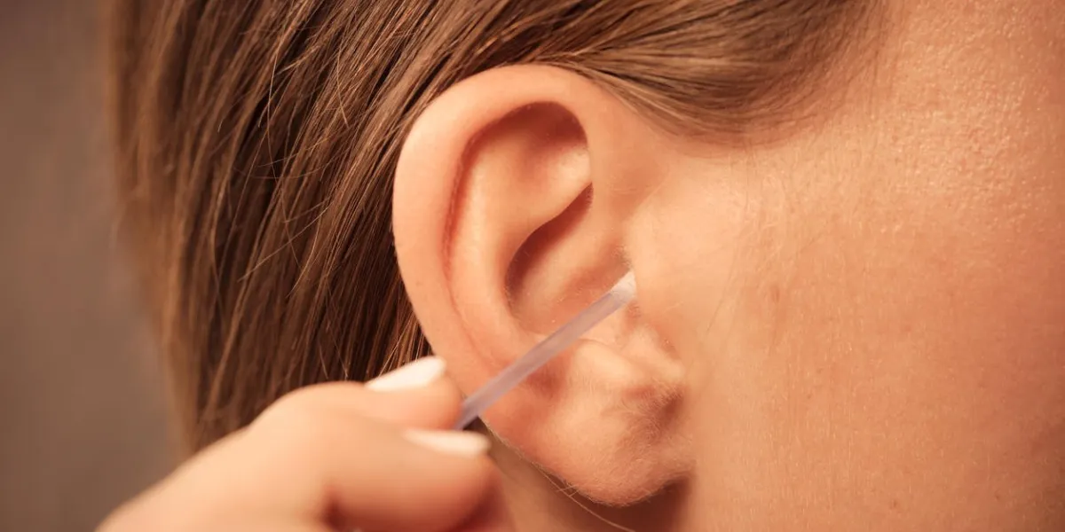 concept d'hygiène femme nettoyage des oreilles avec des cotons-tiges de coton closeup