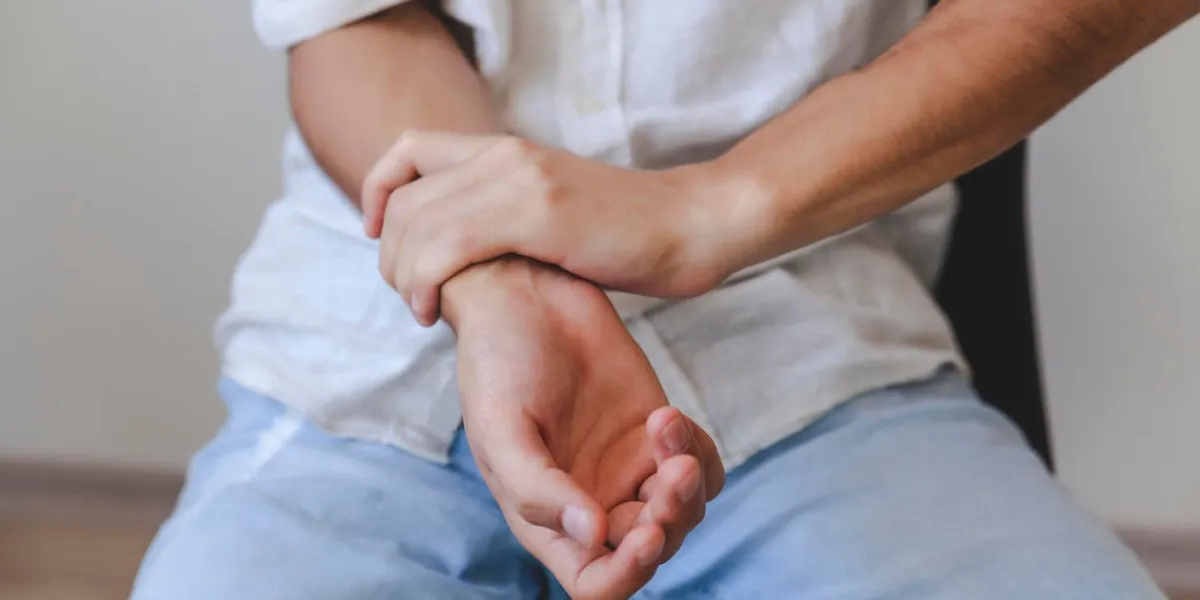 closeup of male arms holding his painful wrist caused by prolonged work on the computer, laptopcarpal tunnel syndrome, arthritis, neurological disease concept numbness of the hand