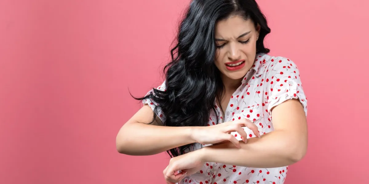 young woman scratching her itchy arm skin problem