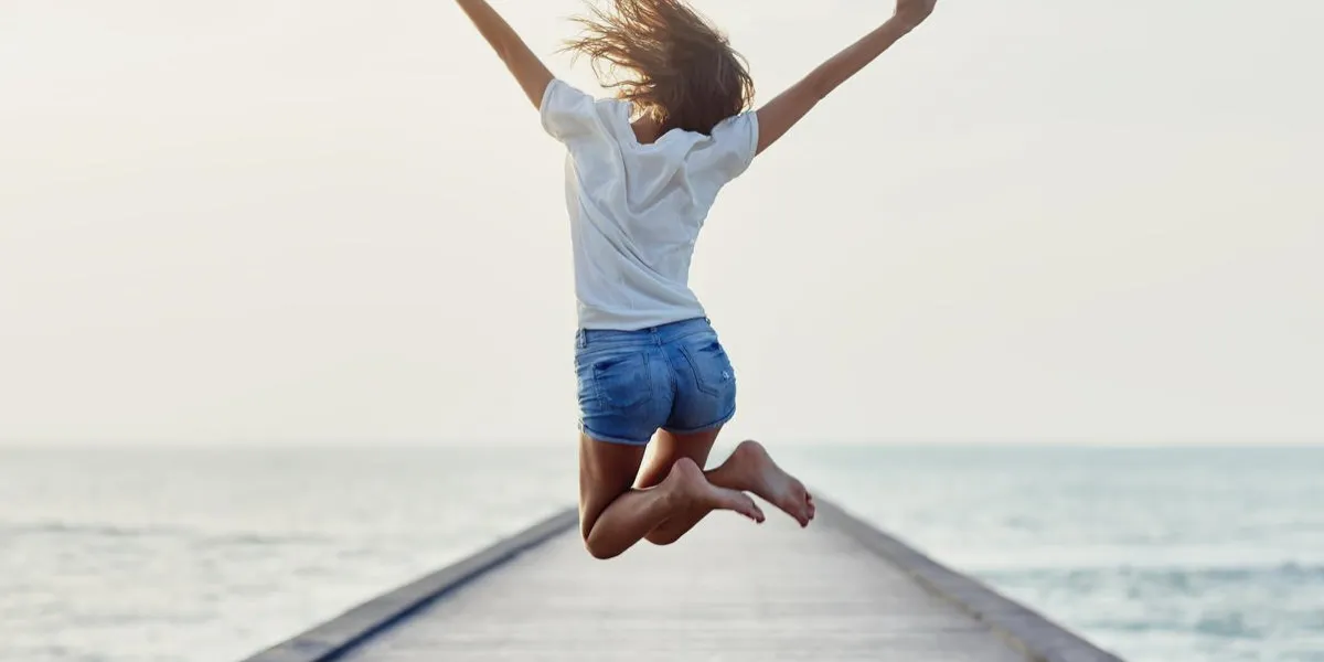 vue arrière de la fille sautante sur le concept de liberté de la jetée