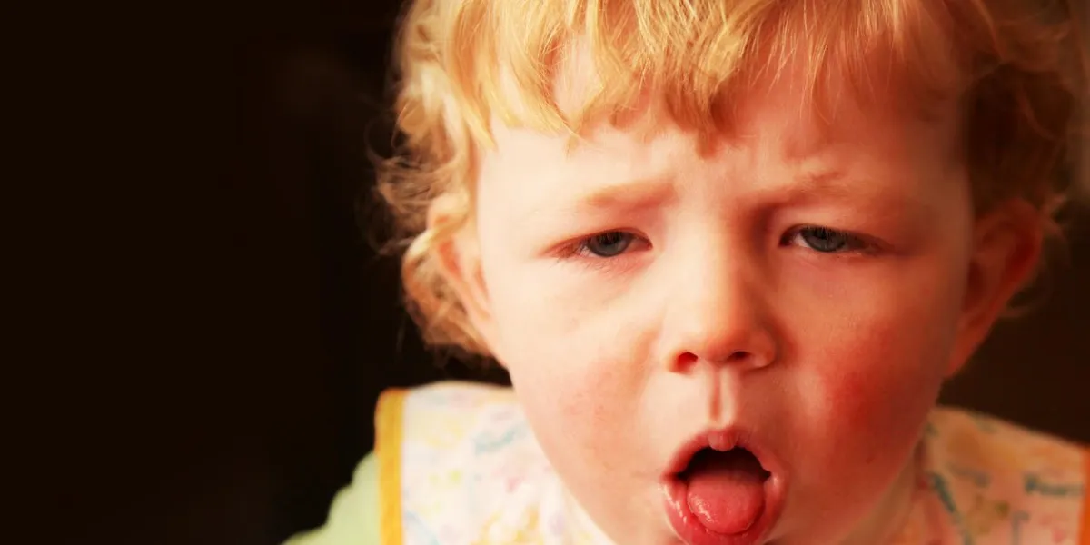 un jeune garçon (18 mois) avec une toux méchante, toussant avec sa bouche ouverte et la langue piquer