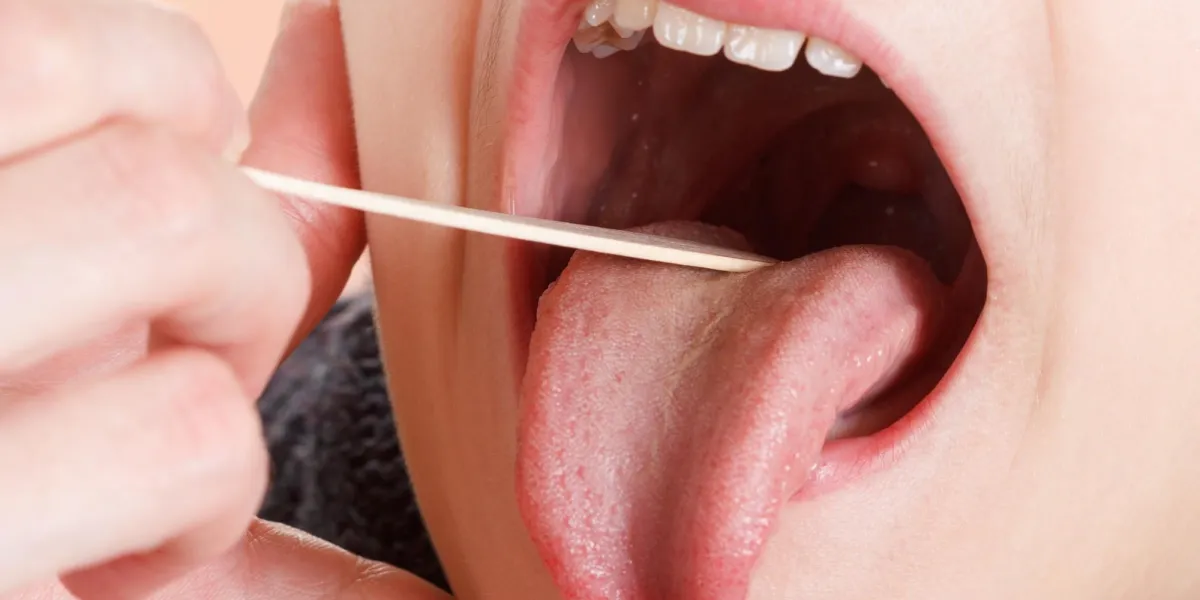 child with doctor boy in the office of a pediatrician, medical examination pharynx and tonsils