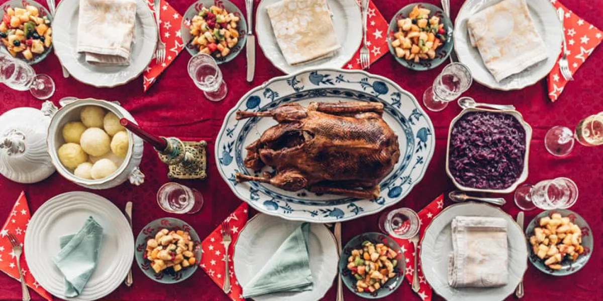 overhead view festive decorated christmas table with traditional goose roast and dumplings without people