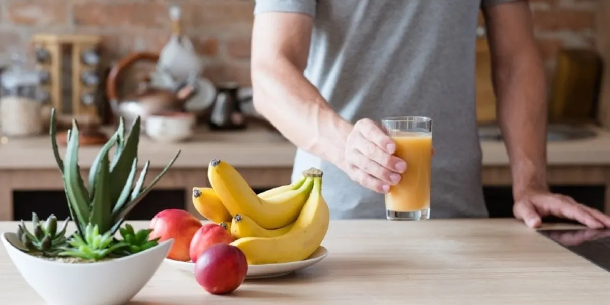 healthy eating habit unrecognizable man holding a glass of freshly squeezed fruit juice natural organic banana and nectarine drink balanced diet and nutrition