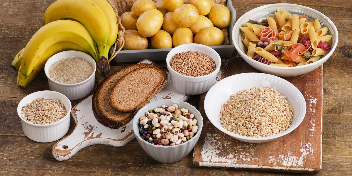 foods high in carbohydrate on wooden background top view