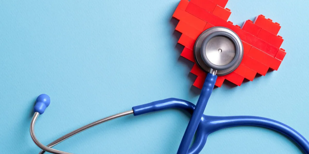 blue stethoscope standing on red heart on blue background