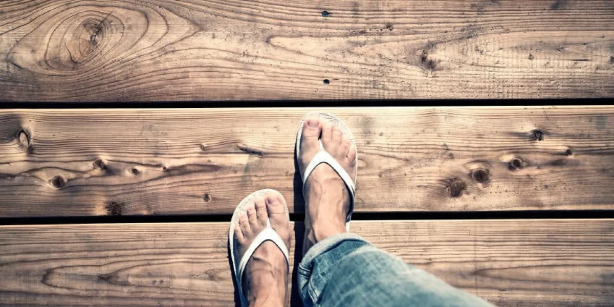une femme marchant sur un plancher en bois, point de vue perspective une femme avec des tongs blanches et jeans marchant seul sur vieux pont en bois conceptuel photo, point de vue perspective utilisé