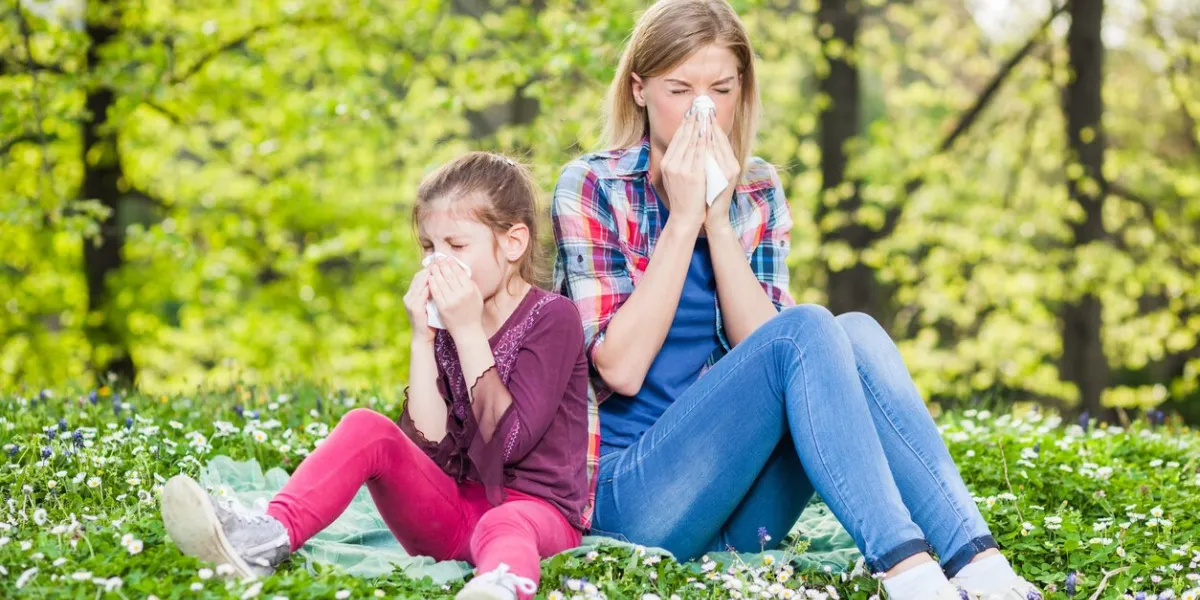 two women with allergy symptom blowing their noses