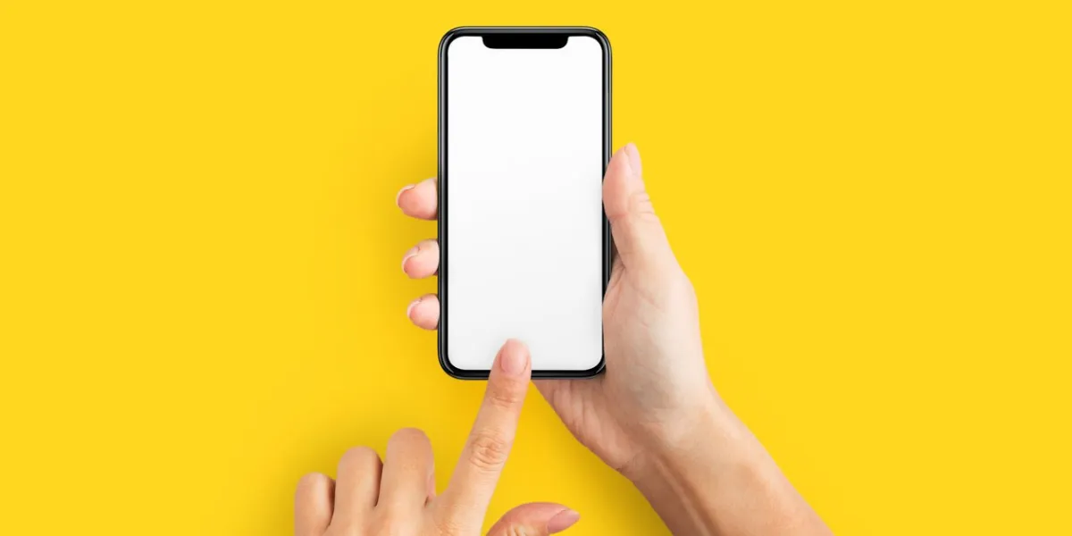 mockup of female hands touching cell phone with blank screen on yellow background