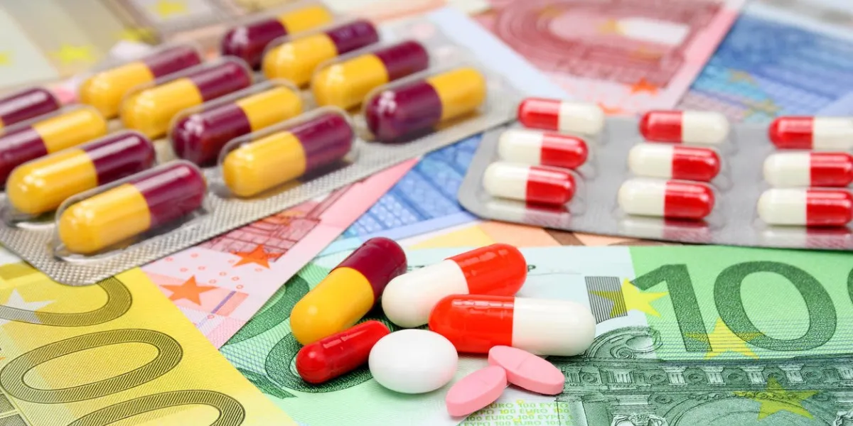 assorted pills and capsules over euro money