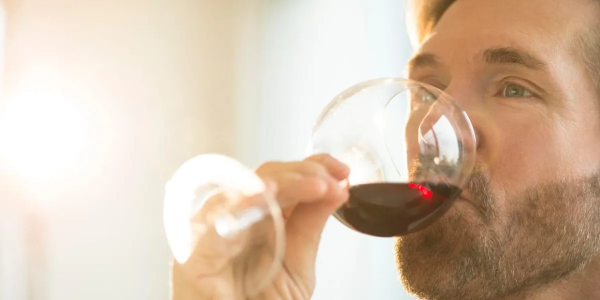 bel homme mature dégustation de vin rouge à la maison