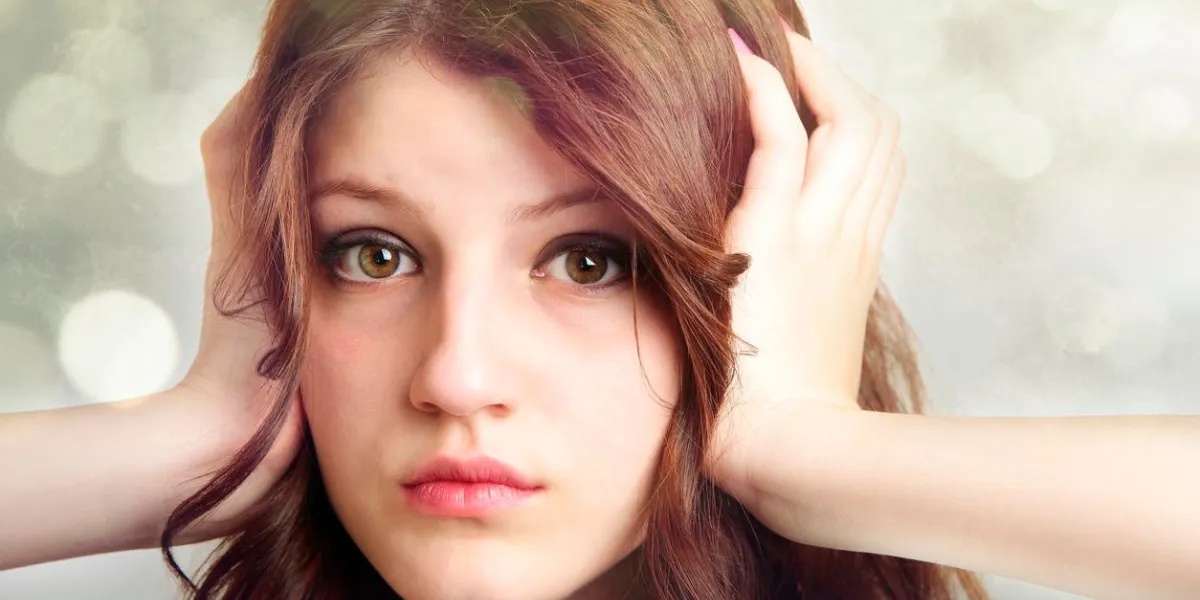 belle adolescente avec les mains sur ses oreilles isolés sur fond blanc