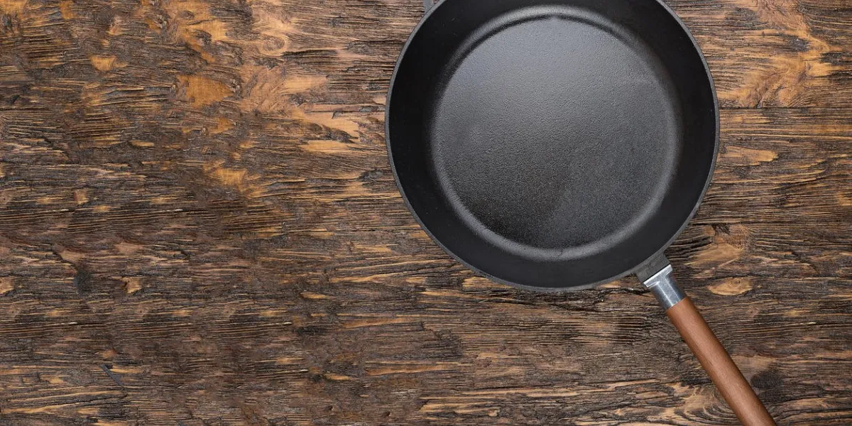 empty cast-iron frying pan on a wooden background