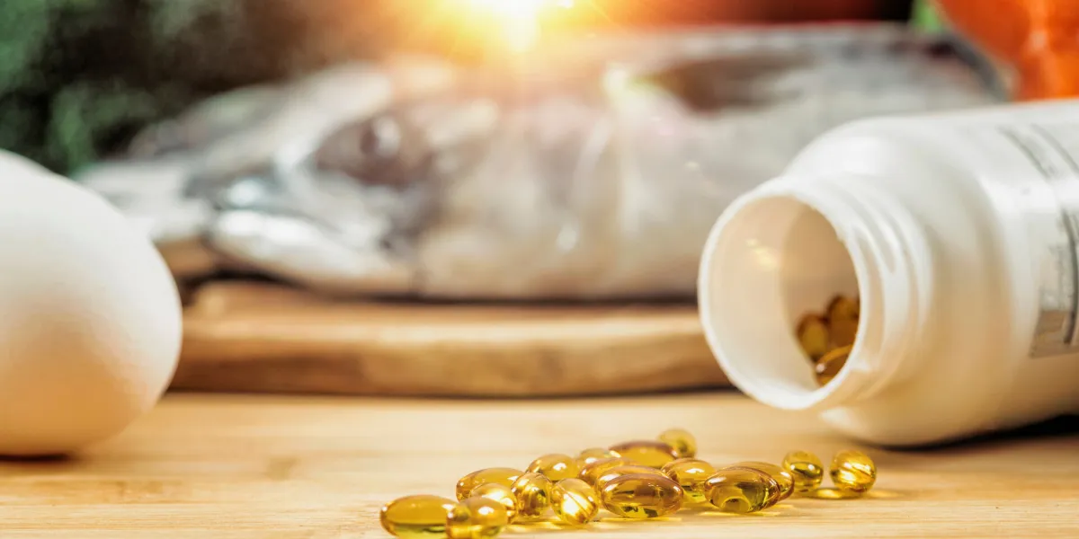 supplement bottle with gel capsules on a wooden table natural food sources of vitamin d in background