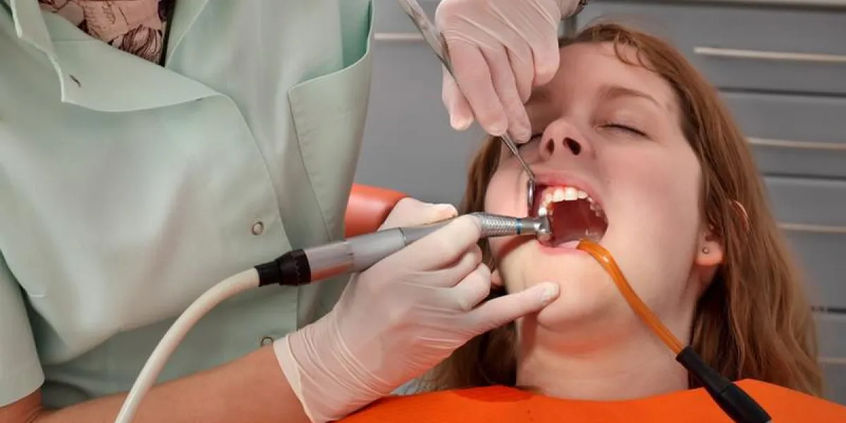 femme médecin dentiste nettoyage et polissage dent de jeune patient