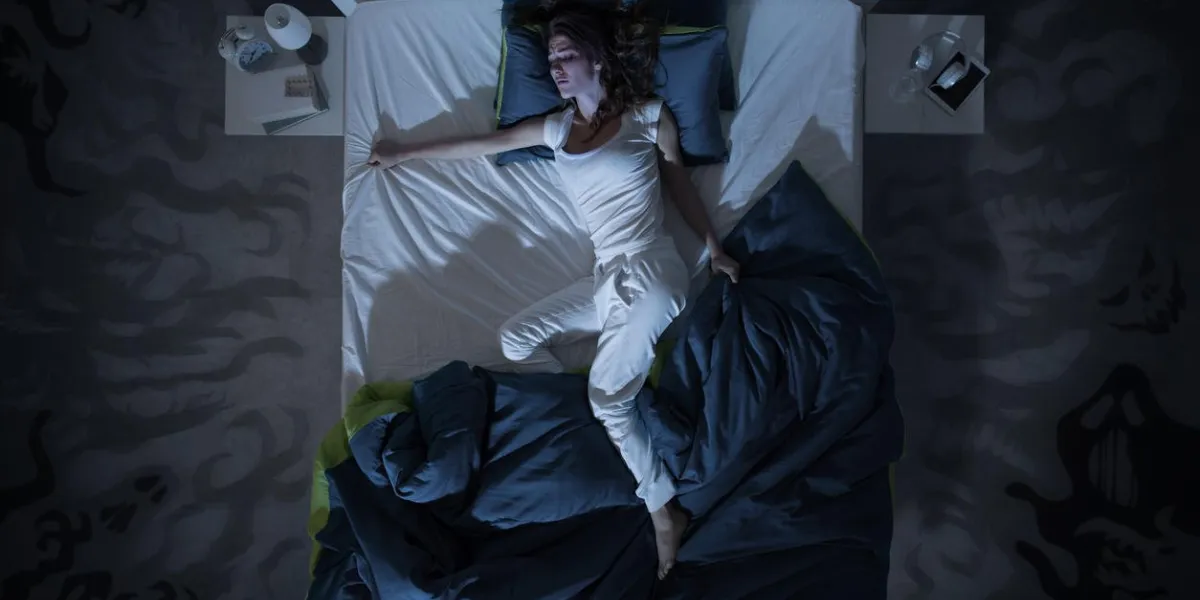 femme nerveuse souffrant d'insomnie et couchée au lit tard dans la nuit, elle est éveillée et agitée, vue de dessus