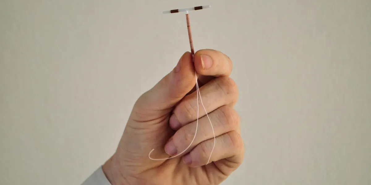 tenant un dispositif de bobine de cuivre de commande de naissance d'iud entre les doigts, utilisé pour la contraception