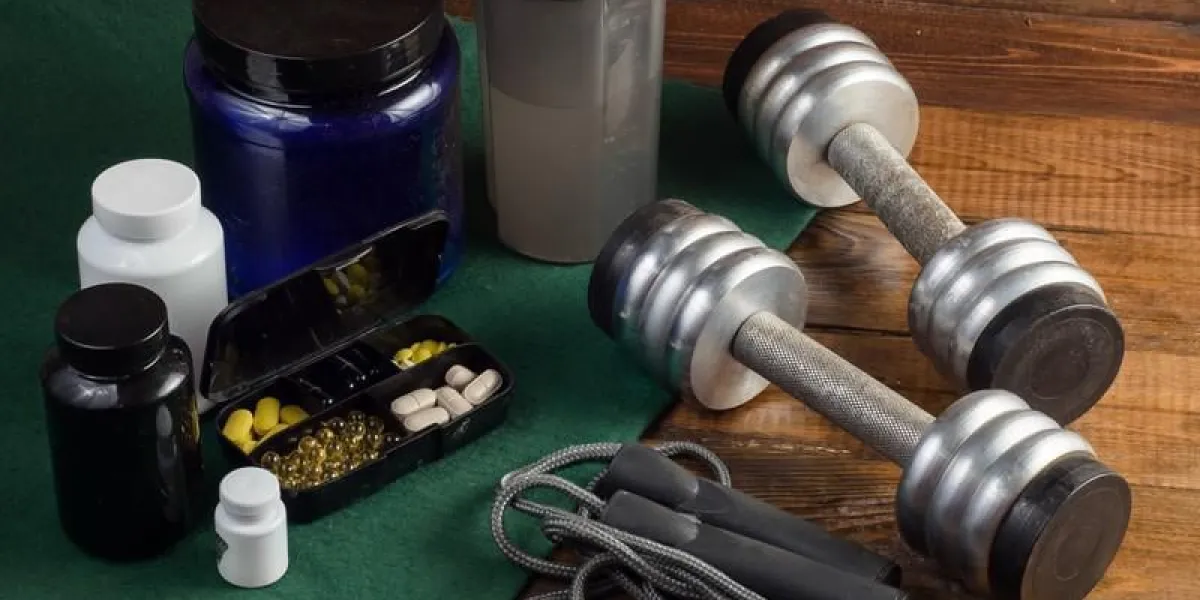 complément sport et fitness, haltères sur fond de bois