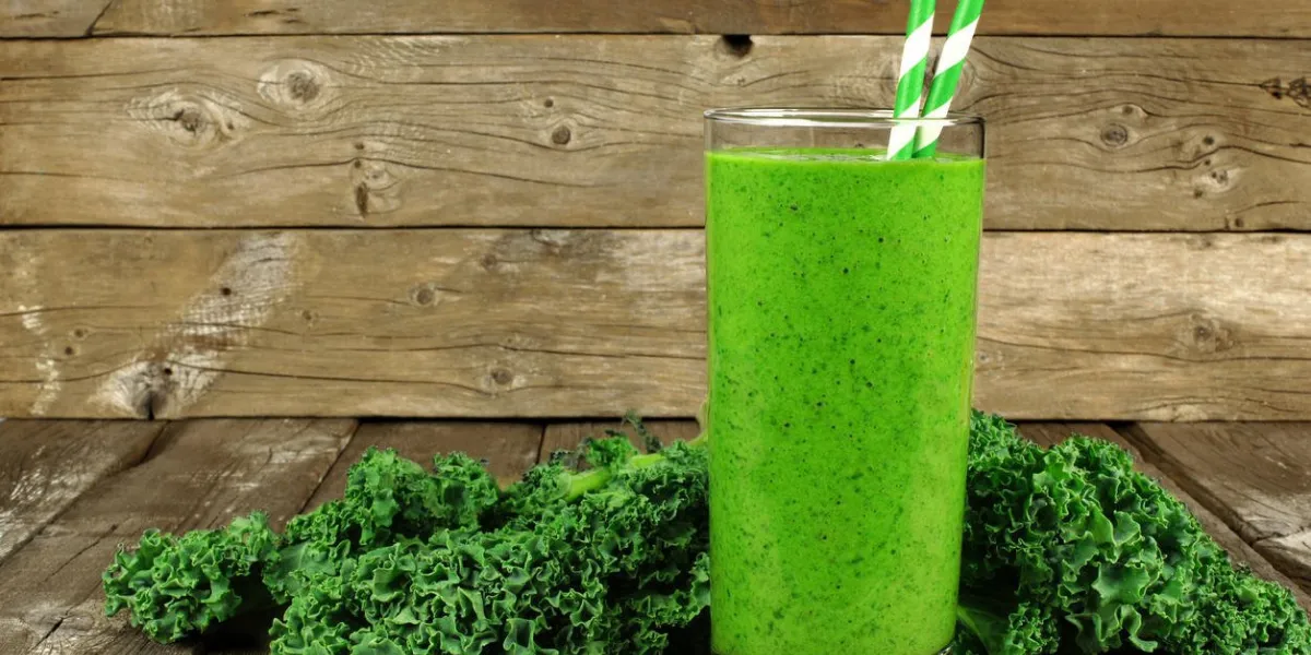 smoothie vert sain avec du chou frisé dans un verre avec des pailles sur un fond de bois rustique