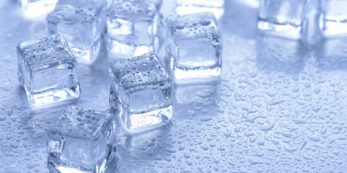 glaçons avec de l'eau tombe sur fond bleu
