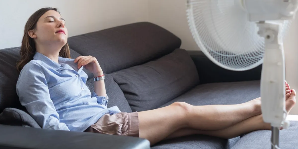 jeune femme rafraîchissante devant un ventilateur