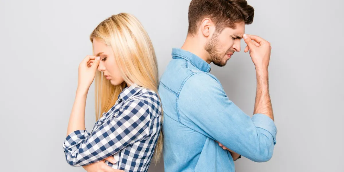 man and woman standing back to back after quarrel