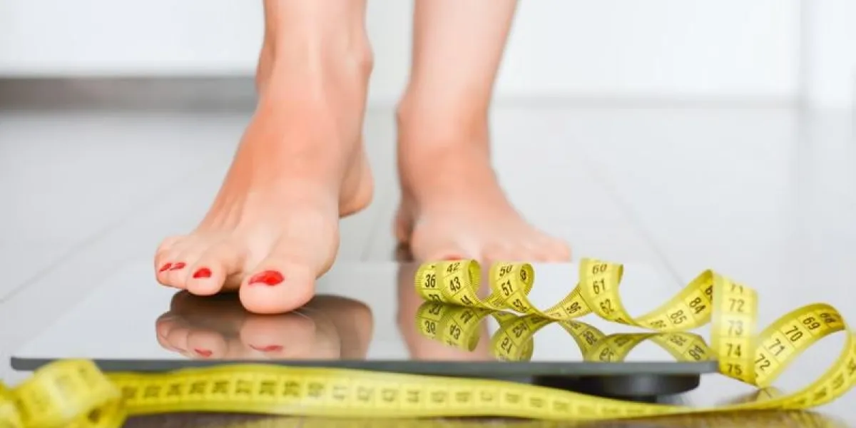 concept de silhouette parfaite avec une femme sur une échelle de poids