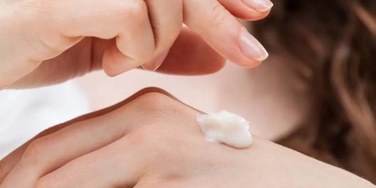 closeup shot of woman hands applying moisturizing hand cream