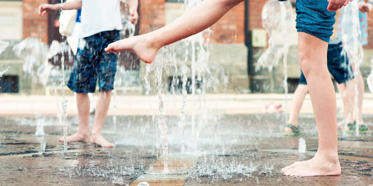 summertime enjoyment kids legs and feet wet in fountain outdoors